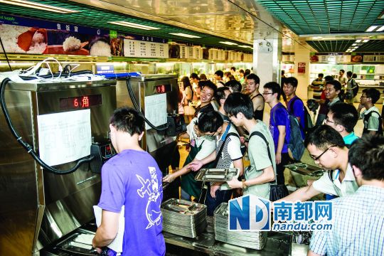 昨日，華南理工大學一食堂內(nèi)，學生們正在使用新安裝的自動打飯機打飯。中新社發(fā)
