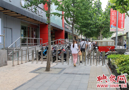 圖中道路左側(cè)的無(wú)障礙通道被鋼管隔離,右側(cè)的盲道也被侵占。