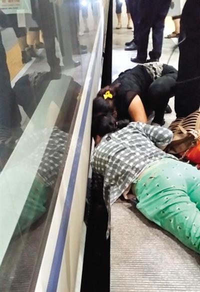 一女子趴在站臺(tái)上，救跌入列車和站臺(tái)間隙的男童。網(wǎng)友璀璨的星月夜 攝