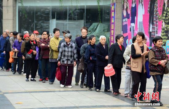 圖為10月28日，在江西九江市一家羊絨皮草服裝服飾博覽會(huì)現(xiàn)場，老人們正在頂著寒風(fēng)排隊(duì)等待領(lǐng)取10元代金劵。