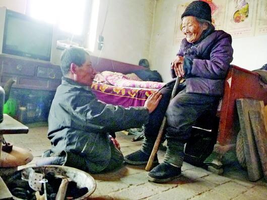 52歲的劉蘭山每天靠爬行照顧90歲的老母親。孫國(guó)祥 攝