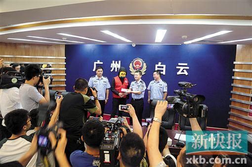 因舉報涉毒案件線索而獲獎的“快遞小哥”戴著面具領取獎金。