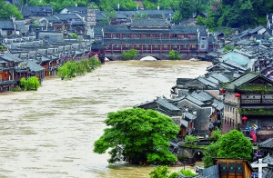 7月16日,沱江兩邊的商鋪和遠(yuǎn)處的虹橋仍淹沒(méi)在洪水中。 新華社發(fā)