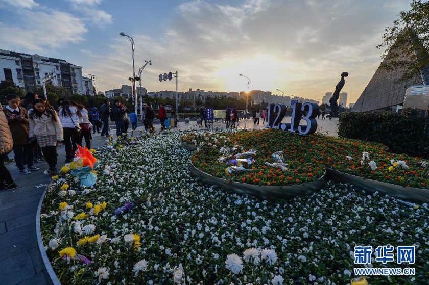 12月14日,觀眾在侵華日軍南京大屠殺遇難同胞紀(jì)念館前的“12·13”花壇上擺放鮮花祭奠遇難同胞。新華社記者 沈鵬 攝