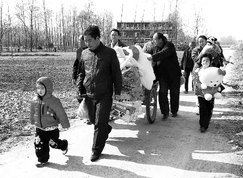 姐（左一）弟（右一護(hù)士懷中男嬰）返鄉(xiāng)，愛(ài)心捐贈(zèng)滿滿一架子車(chē)。