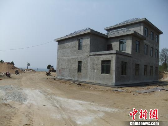 鴨河水庫庫區(qū)邊的新建別墅，一面墻上寫著“拆”，另一邊在加緊施工。吳揚　攝