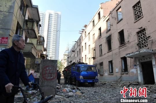 一位花甲老人站在即將拆除的樓房旁，默默地與“蘇聯(lián)樓”告別。　翟羽佳　攝