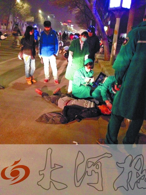 醉漢躺在地上，醫(yī)護(hù)人員對(duì)其進(jìn)行檢查。